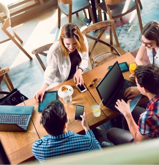 A group of young professionals working together at a table in a cafe