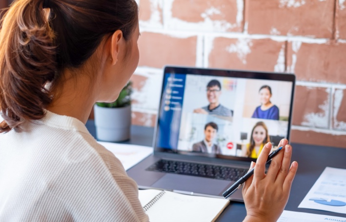 A woman engaging with colleagues in a virtual video conference