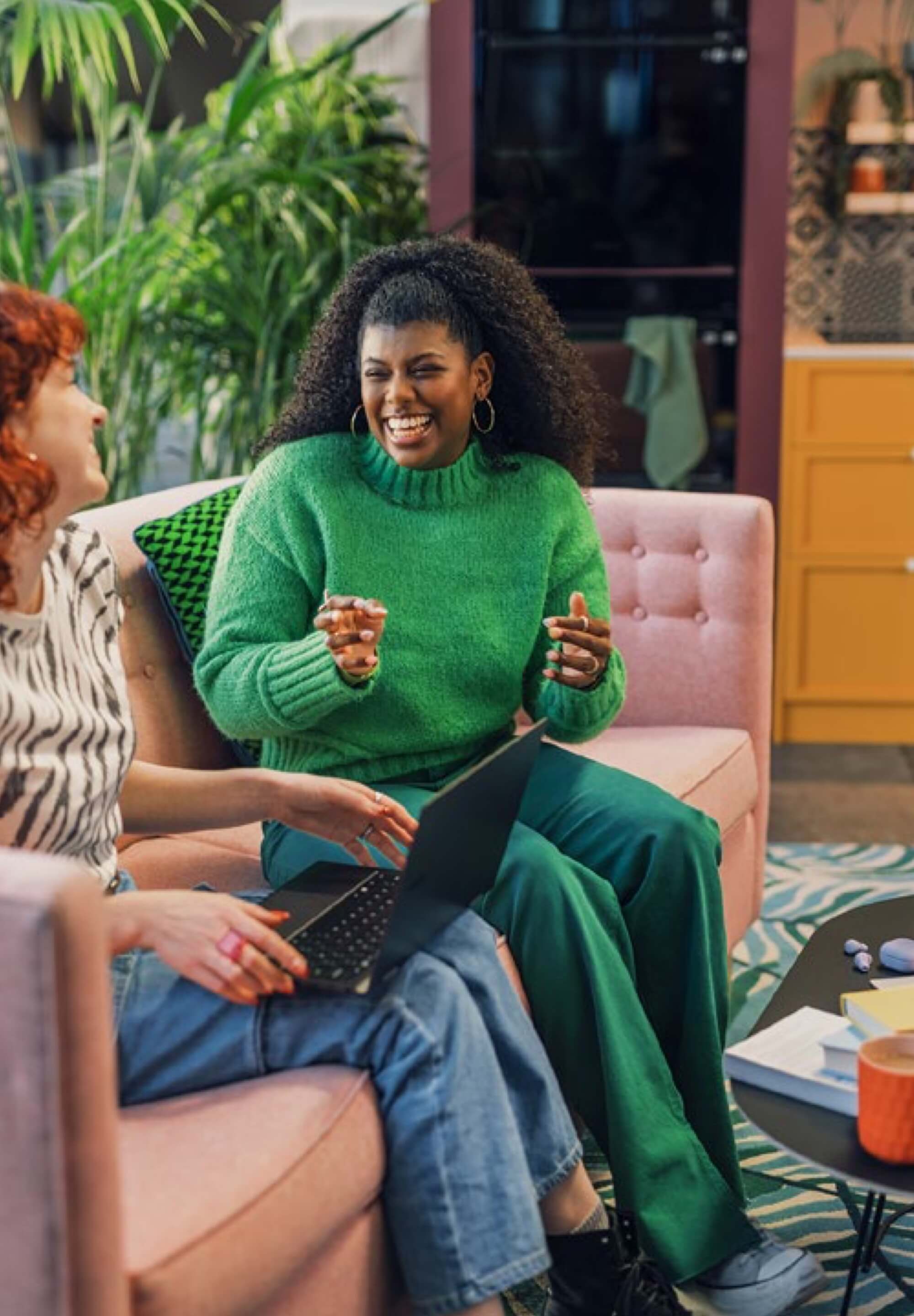 Two happy female colleagues enjoying a conversation in a breakout space