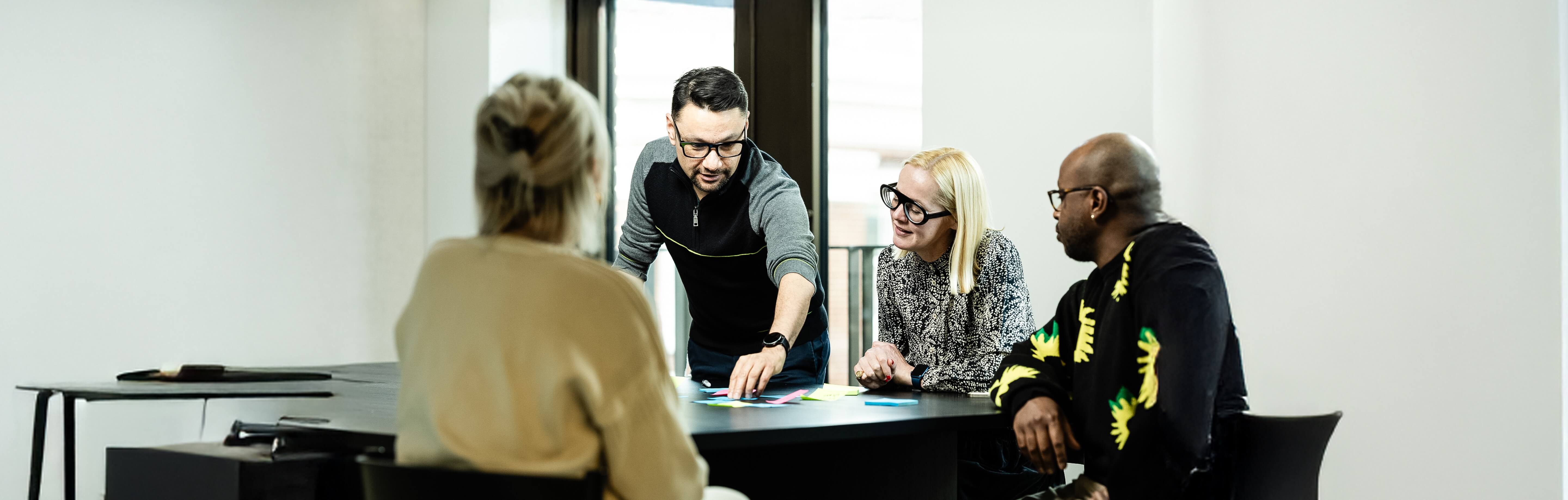 A group of people engaged in a lively discussion round a meeting room table
