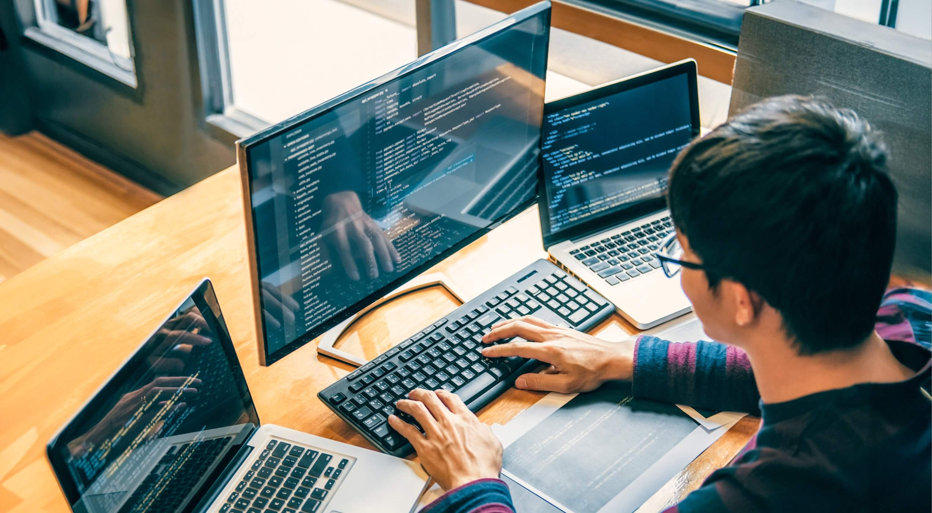 A digital developer writing code on a computer