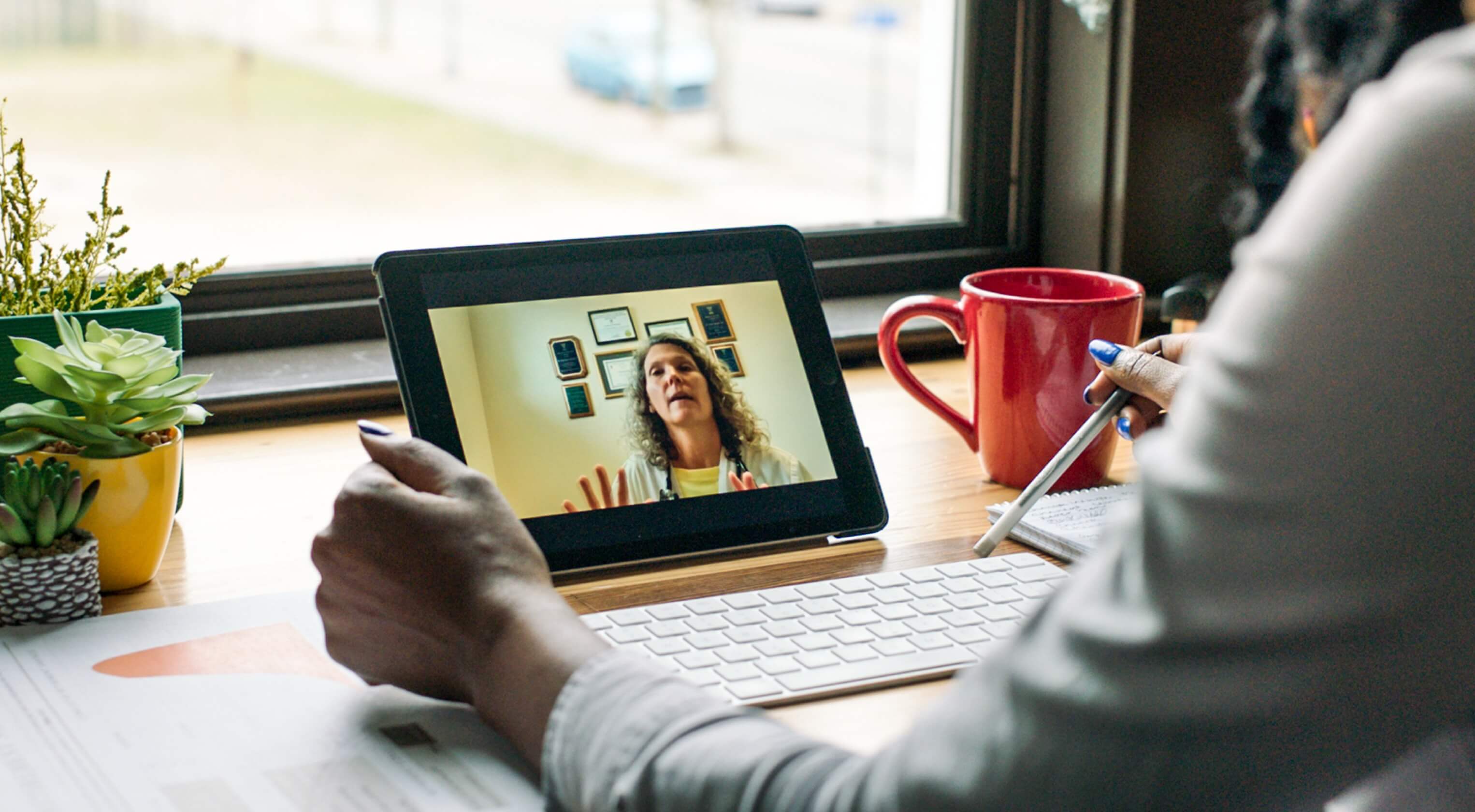  A woman engaged in a video call with her colleague on a tablet computer