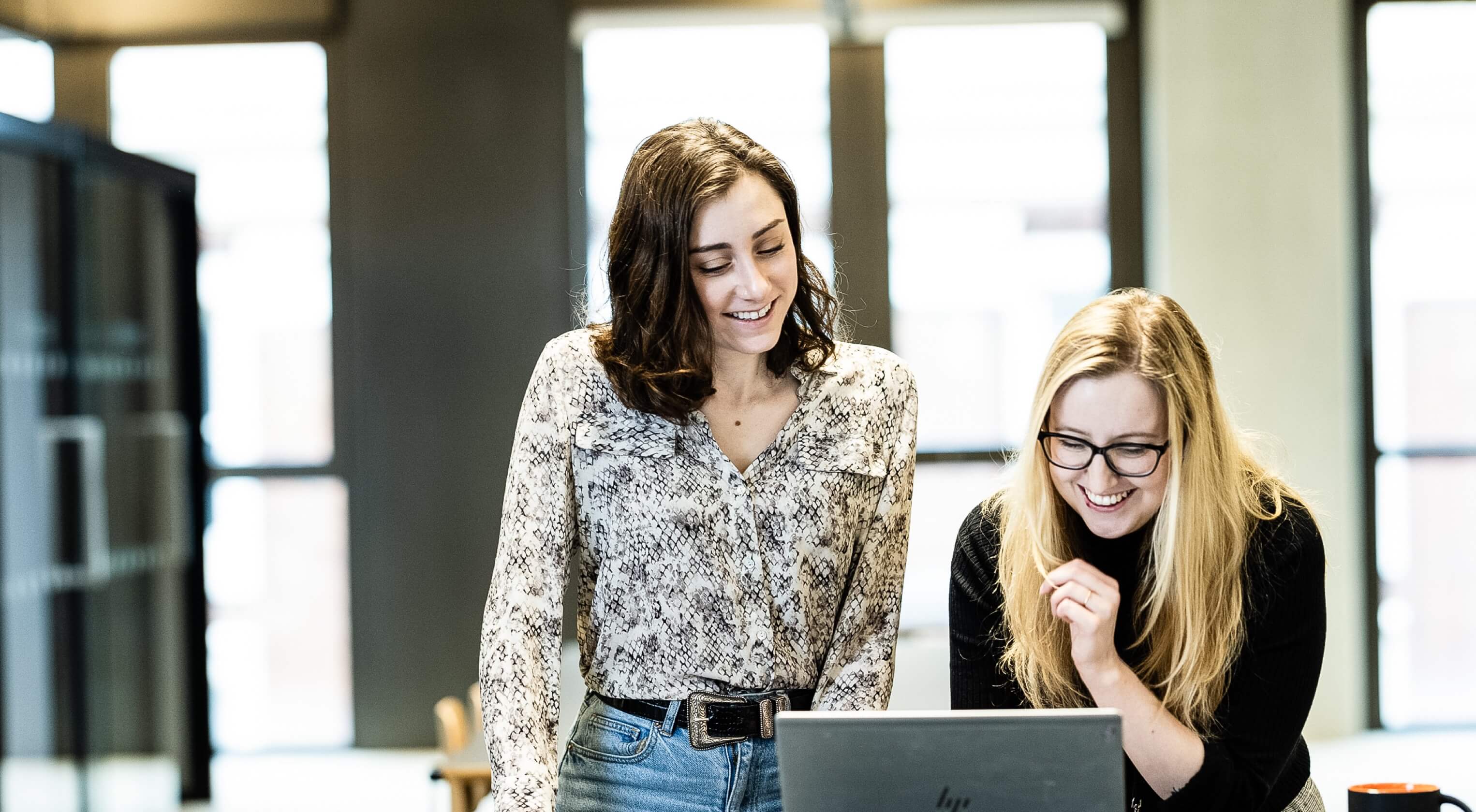 Two women engaged in a conference call on a laptop computer