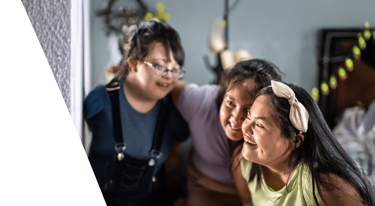 Three young girls with downes syndrome happily hugging one another