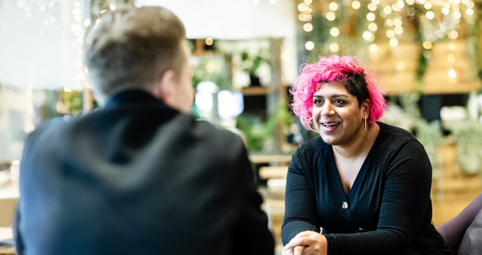 A young woman sat talking with a young man