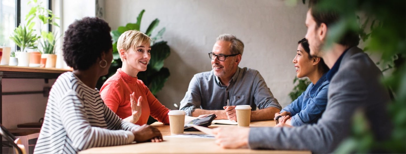  A group of smiling coworkers having a meeting in a local cafe