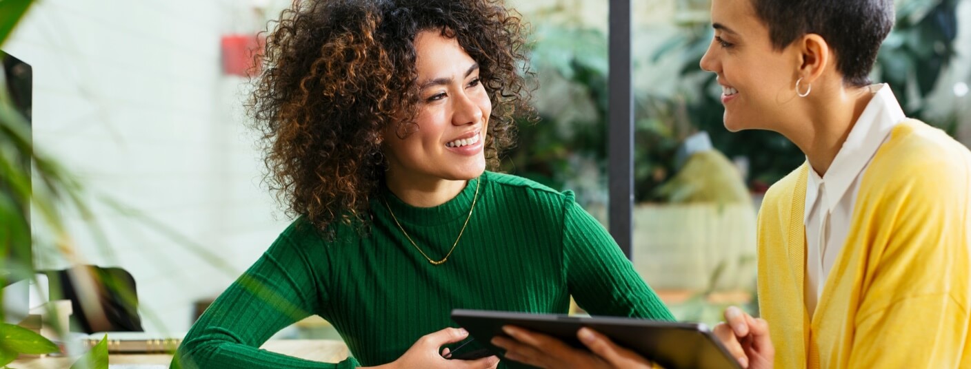 Two professional women having a discussion whilst looking at a tablet computer