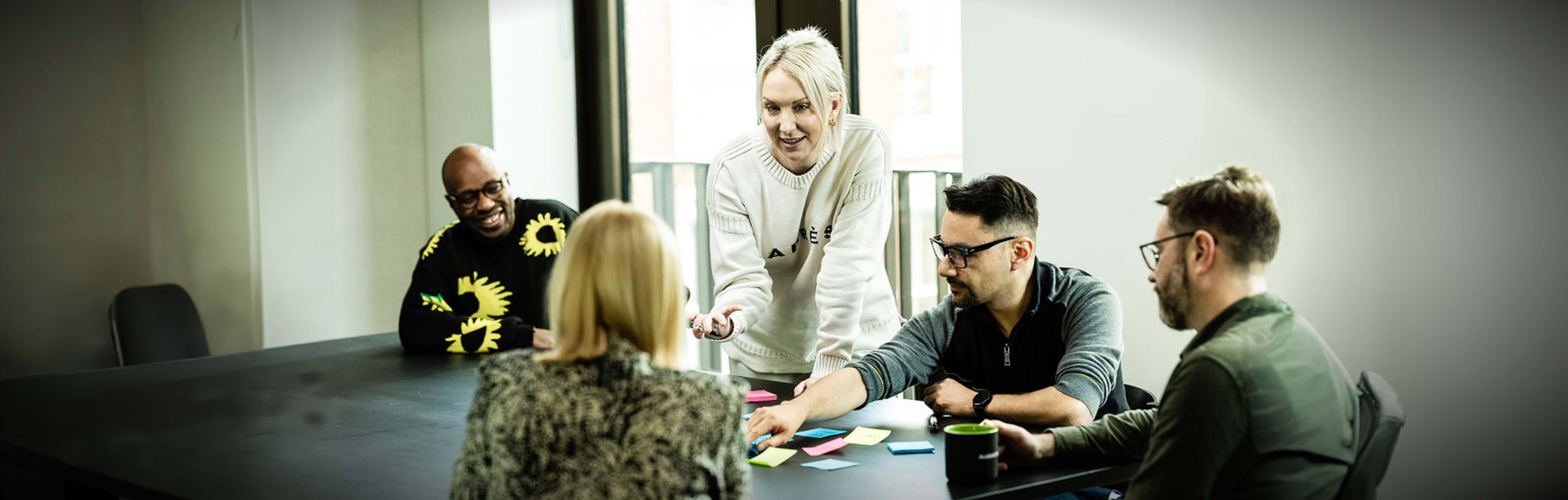 A group of people engaged in a lively discussion round a meeting room table