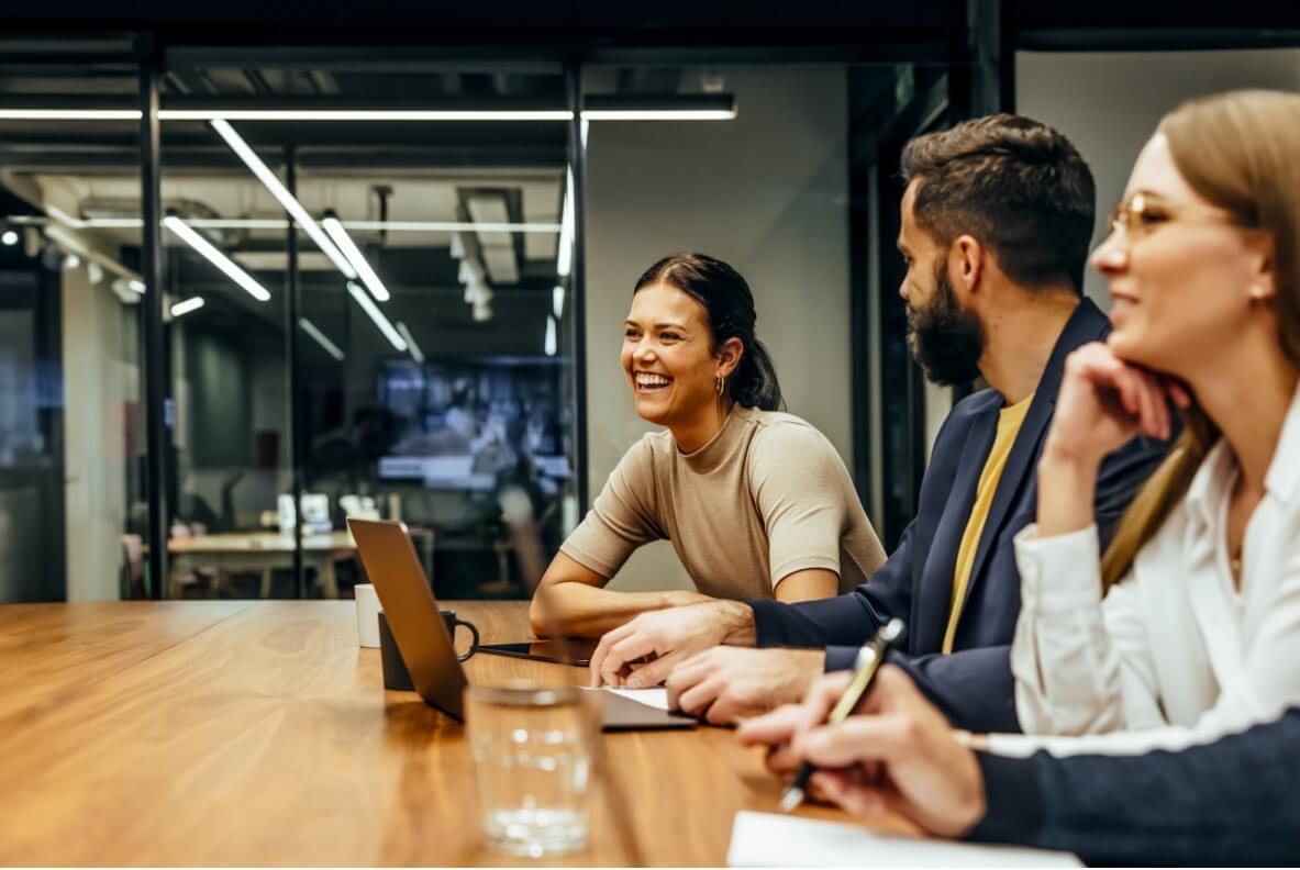 A businesswoman laughing during a meeting with colleagues